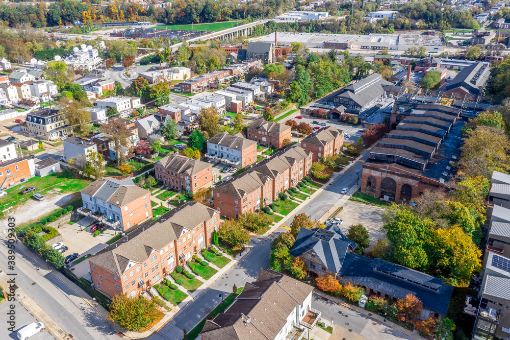Aerial view of regentrified Woodberry neighborhood in Baltimore Maryland with brick townhomes, former foundry factory converted to luxury apartments 