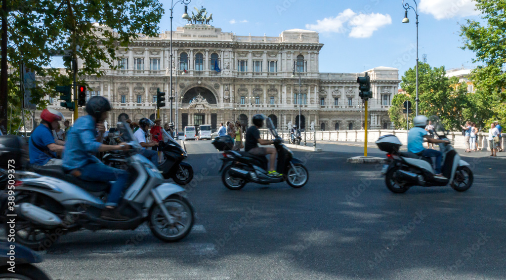 Scooters and tourists in the city of rome, corte di cassazione supreme court in the background.