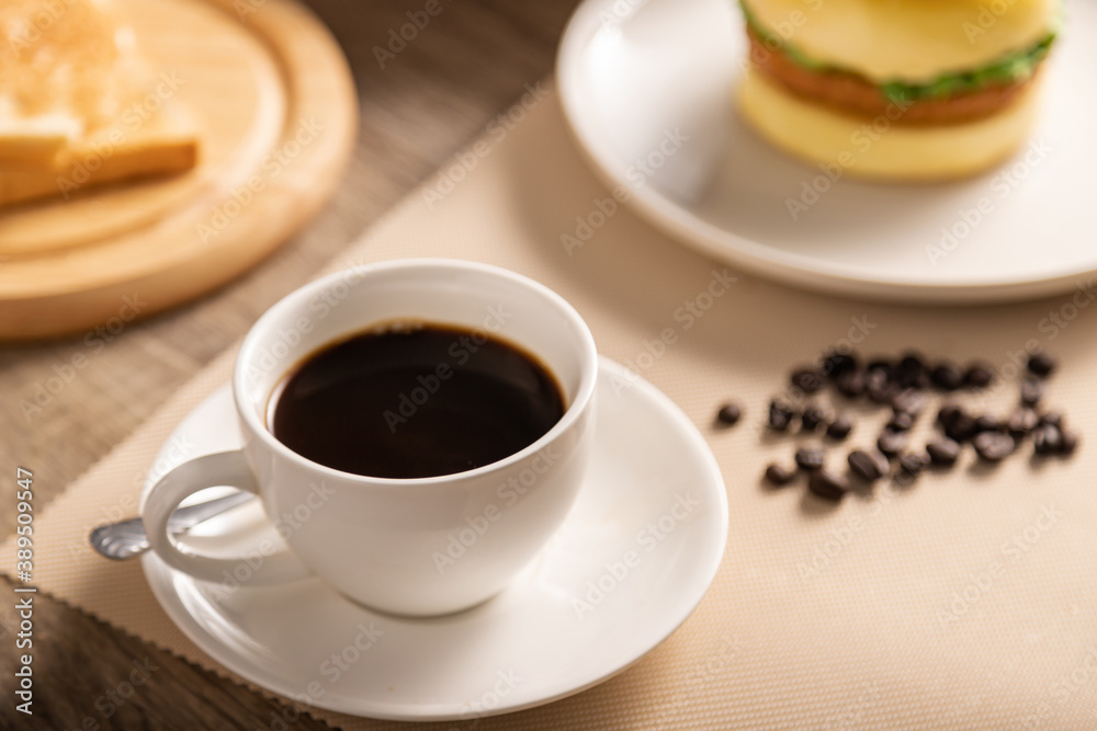 The hot black coffee cup in white glass and breakfast on the wooden table The hot black coffee cup in white glass and breakfast on the wooden table