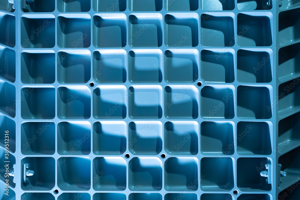 Obraz premium Industrial background. Light blue background with metal lattice. Metal latticeon industrial equipment. Abstract industrial texture. Metal lattice on production machine. Background on theme production