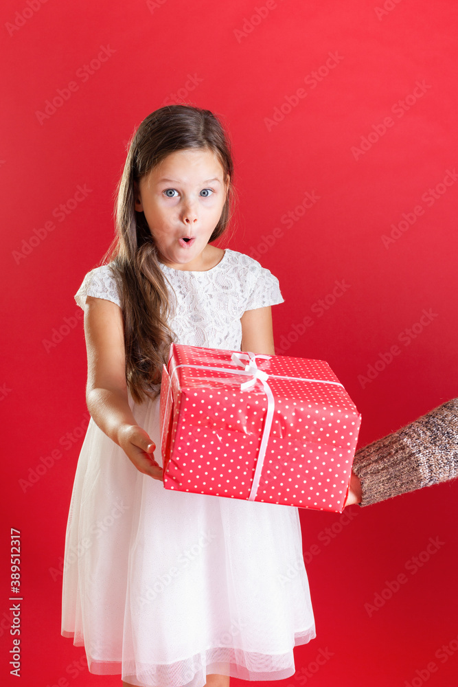 close up a girl in white is surprised to accept a red gift box from another person on an isolated background. close up a girl in white is surprised to accept a red gift box from another person on an isolated background.