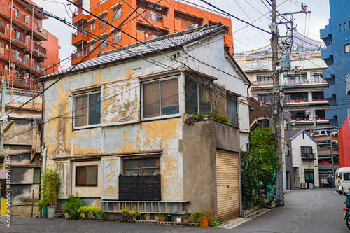 Buildings of Tokyo. Cities of Japan. Dilapidated building on streets of Tokyo. Small old house in middle of high-rise buildings. Architecture of capital of Japan. Streets of Tokyo in autumn.