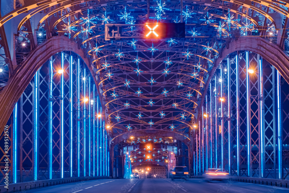 Bolsheokhtinsky bridge in Saint Petersburg. Road architecture of Russia. Christmas illumination inside bridge. Cars are driving across New Year Saint Petersburg.