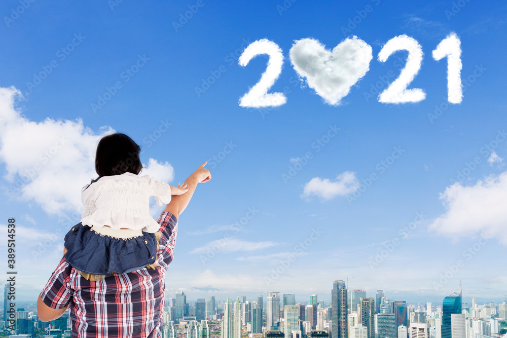 Child and father look at clouds shaped number 2021 Child and father look at clouds shaped number 2021