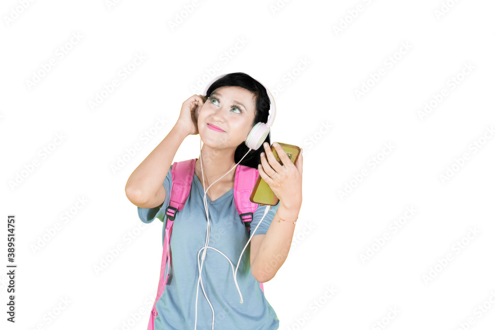 Female student enjoying music by using a headset Female student enjoying music by using a headset