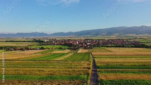 Flying towards Sancraieni, idyllic European village among farmland, Romania photo