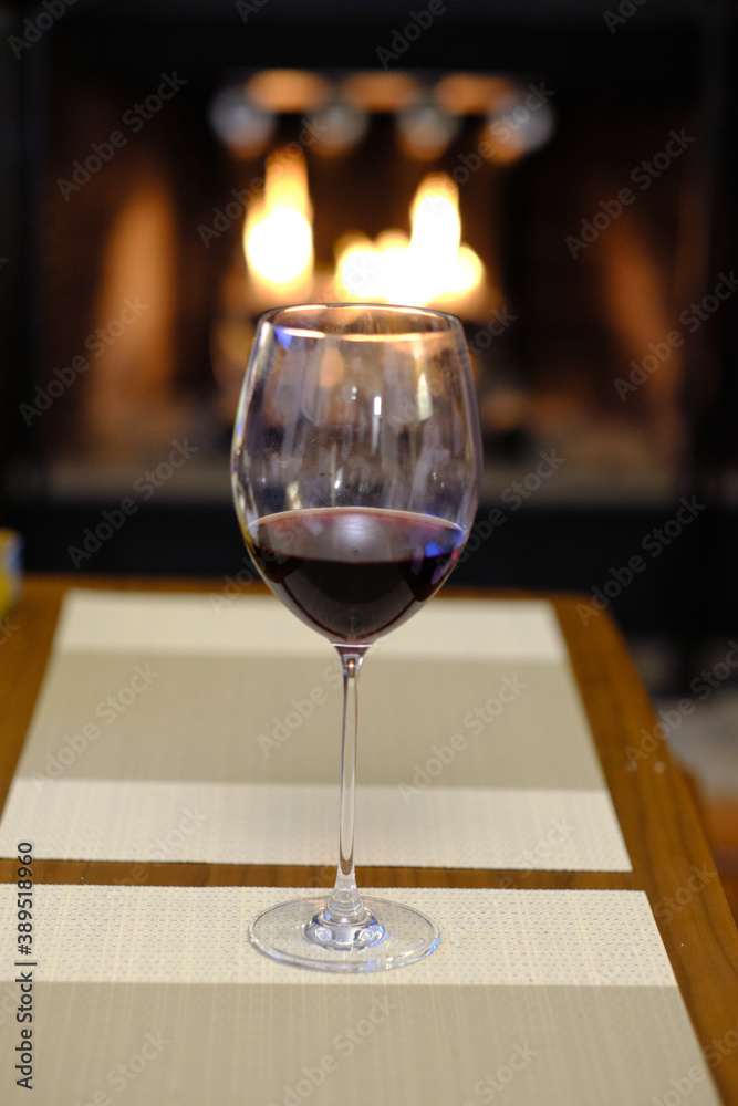 Glass of wine by the fireplace Glass of wine by the fireplace