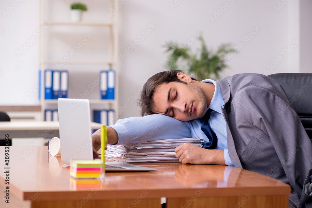 Young male employee sleeping in the office Young male employee sleeping in the office