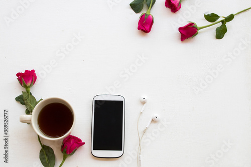 Fototapeta Naklejka Na Ścianę i Meble -  mobile phone ,hot coffee and rose flower of lifestyle woman relax in winter season arrangement on background white