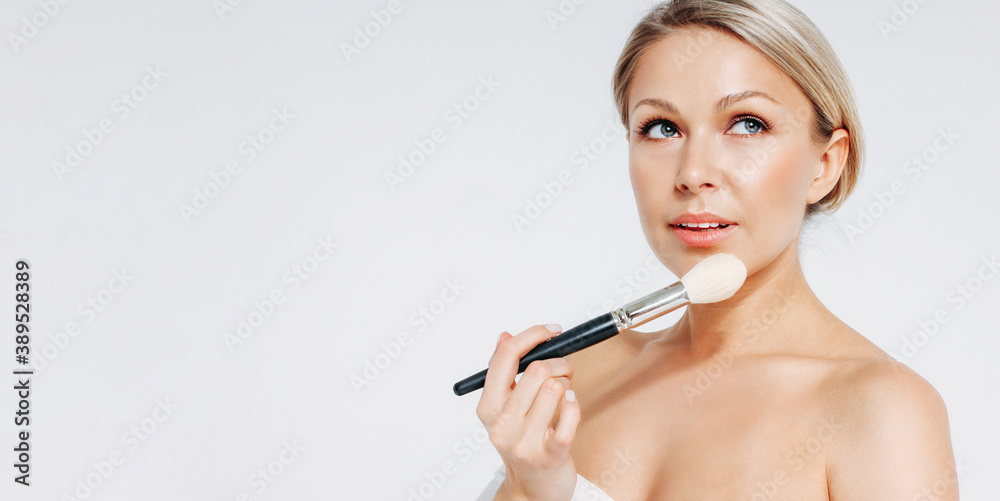 Beauty blonde smiling woman 35 year with brush near clean fresh face isolated on white background, banner Beauty blonde smiling woman 35 year with brush near clean fresh face isolated on white background, banner