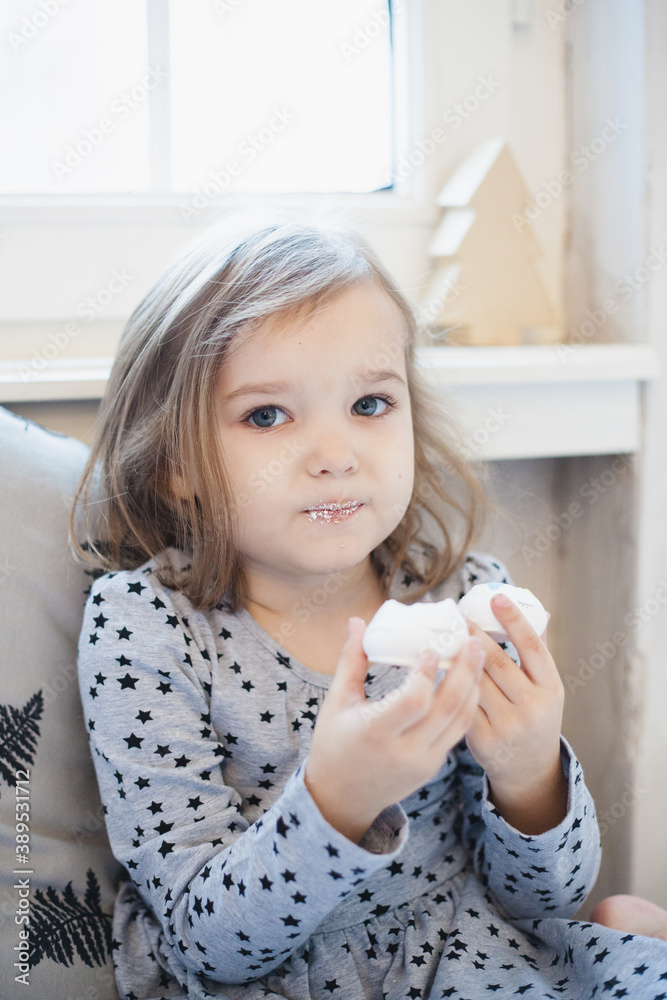 The room is decorated for the new year, a girl near the Christmas tree, waiting for Christmas, ginger cookies