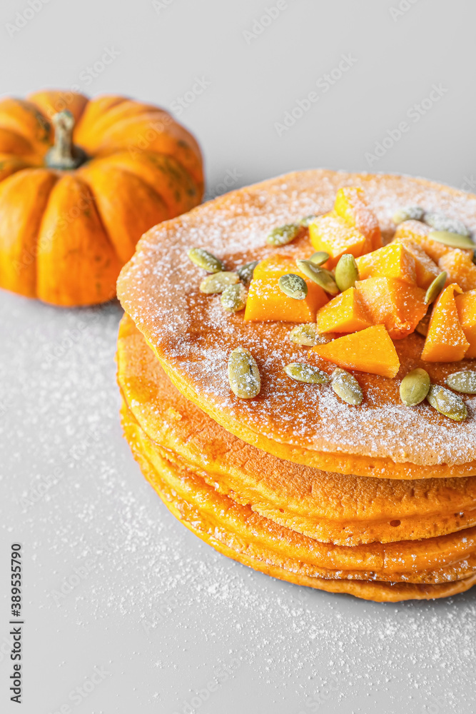 Tasty pumpkin pancakes on grey background Tasty pumpkin pancakes on grey background