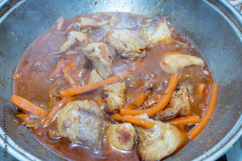 meat with carrots is stewed in a cauldron. Close-up