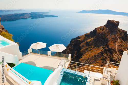 White architecture on Santorini island, Greece. Swimming pool on the terrace with sea view. Beautiful seascape at sunset. Travel destinations concept