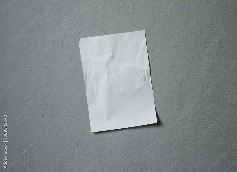 Empty old wrinkled white A4 paper stick on gray cement wall, changeable background. white paper note on gray