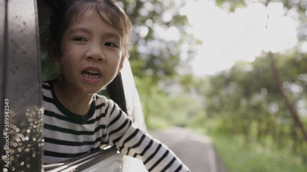 Smiling little Asian girl in car going to summer travel trip. Smiling little Asian girl in car going to summer travel trip.
