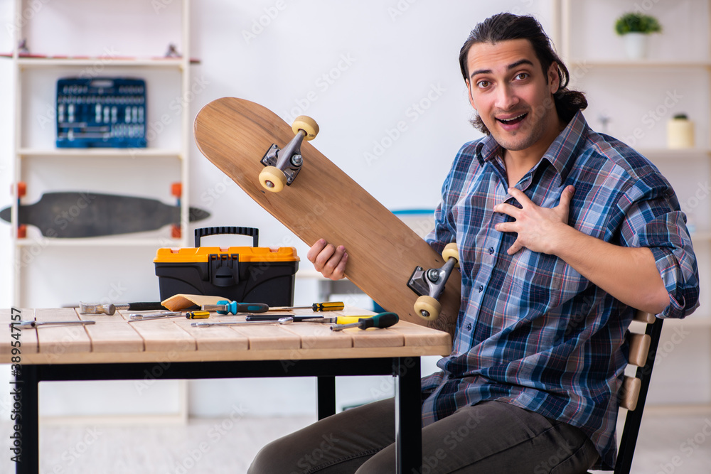 Young man repairing skateboard at workshop Young man repairing skateboard at workshop