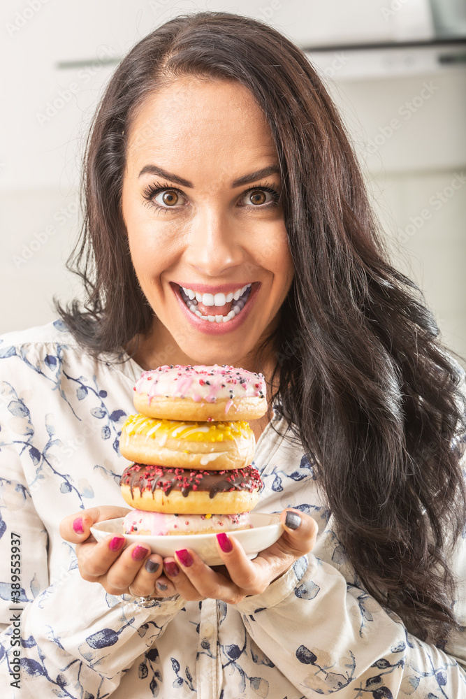 Woman enthusiastically holding plate full of donuts