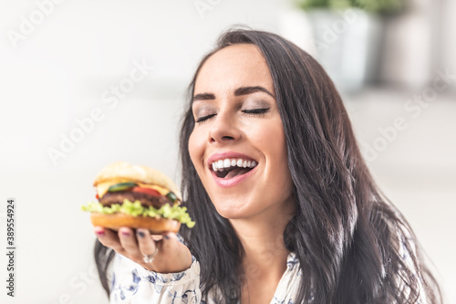 Girl enjoys the smell of a freshly cooked burger in her hand