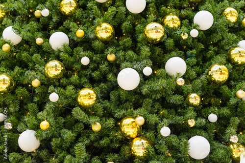 Background from a Christmas tree decorated with gold and white balls.