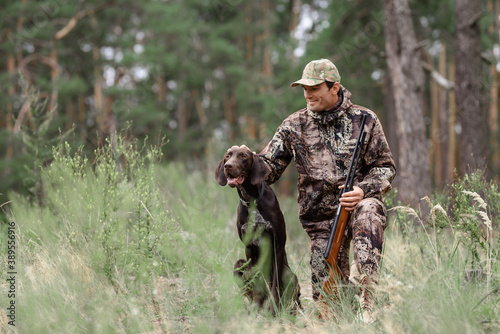 Happy Man with Rifle Hunter Pets Good Hunting Dog.