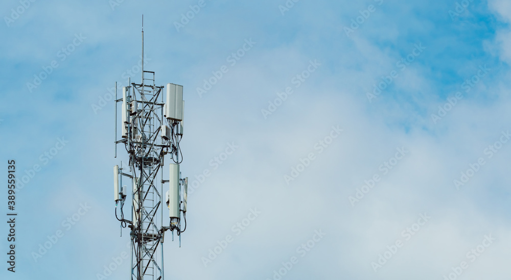 Telecommunication tower with blue sky and white clouds background. Antenna on blue sky. Radio and satellite pole. Communication technology. Telecommunication industry. Mobile or telecom 4g network.