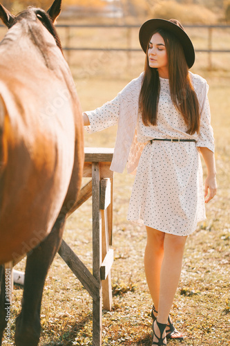 Young beautiful model in a hat on a farm 