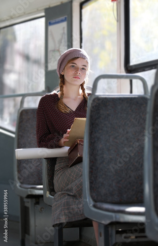 Dreamy girl in retro style clothes in a tram