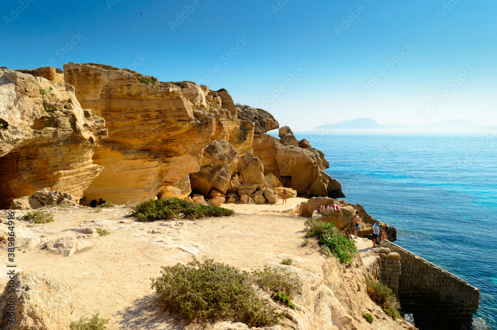 Characteristic tuff stone rocky landscape of the sea coast of Favignana, one of the Egadi islands in Sicily, Italy. Here the Cala Bue Marino one of the most famous beaches