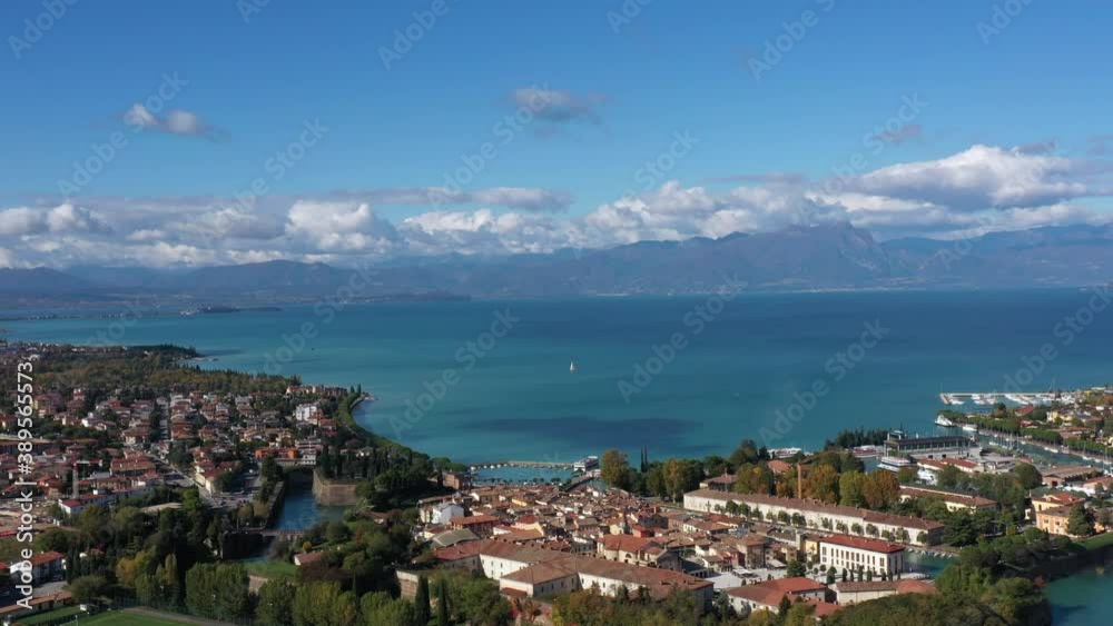 Peschiera del Garda, Italy. Aerial panorama of the resort town on Lake Garda. Italian town on the lake. Small town on the water against the background of water and high mountains top view. Peschiera del Garda, Italy. Aerial panorama of the resort town on Lake Garda. Italian town on the lake. Small town on the water against the background of water and high mountains top view.