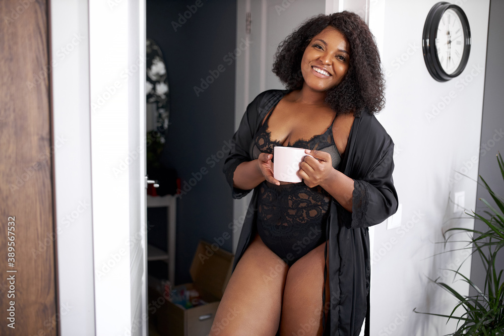 beautiful black overweight lady drinking tea at home in the