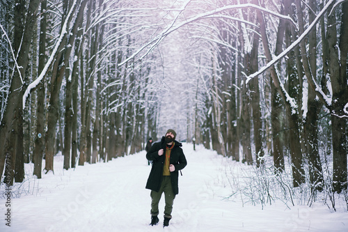 Bearded man in the winter woods. Attractive happy young man with beard walk in the park.