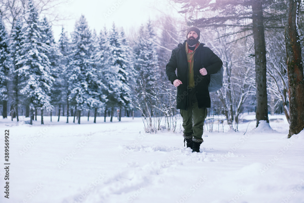 Bearded man in the winter woods. Attractive happy young man with beard walk in the park.