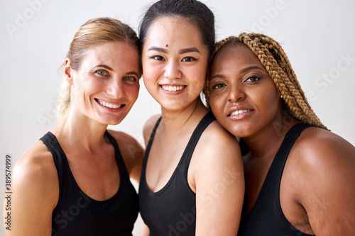 mixed race women of different race, figure and size in black sportswear posing at camera, have fun, cheerful women