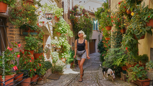 Woman with dog in the street of a small Italian town