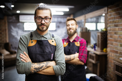 Portrait of young male barbers and hairdressers in barber shop photo
