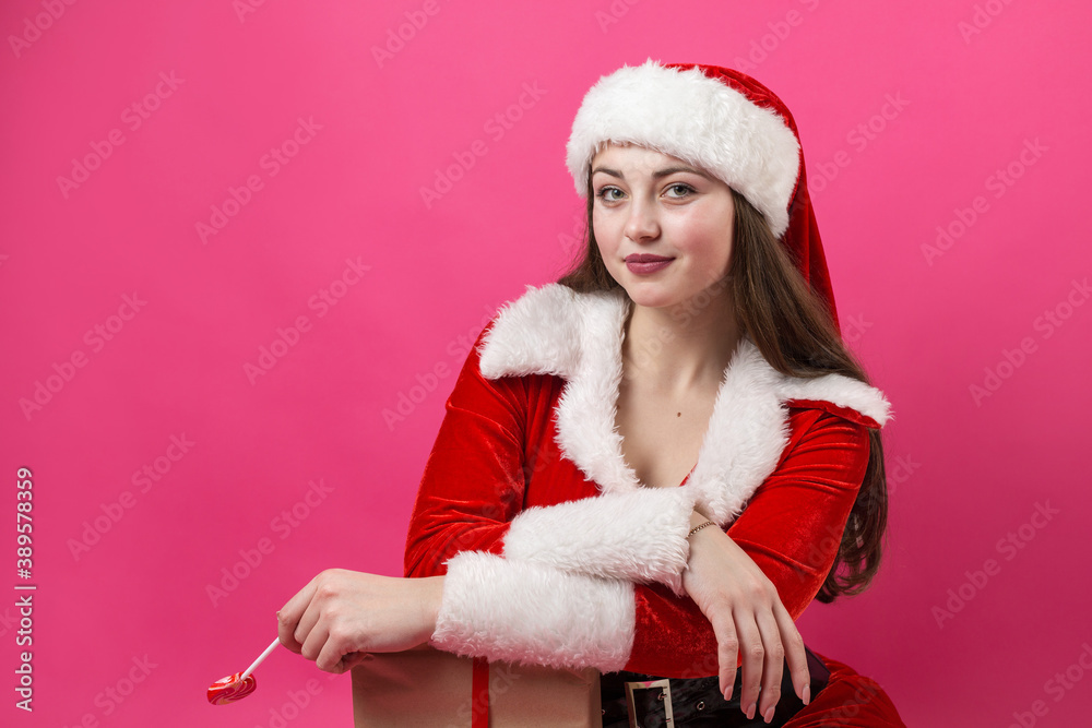 Beautiful young woman in Santa Claus costume against the red background. Beautiful young woman in Santa Claus costume against the red background.