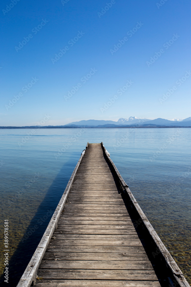 travel germany and bavaria, view above a lake with landing stage and mountain view, Chiemsee, Bavaria, Germany
