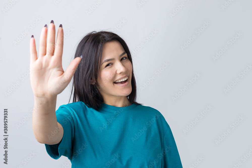 Smiling woman raised her hand palm up and forward like waving. Smiling woman raised her hand palm up and forward like waving.