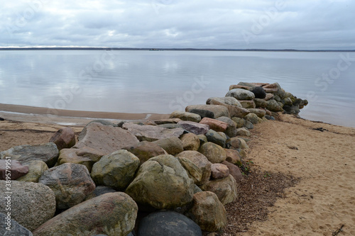 Natural large breakwater stones in the sea on a dark cloudy autumn day. Mood for soothing meditation and relaxation.