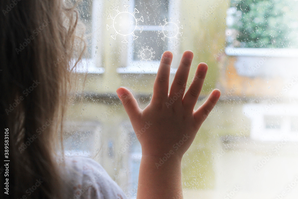 a child looks out the window at isolation due to the coronavirus epidemic