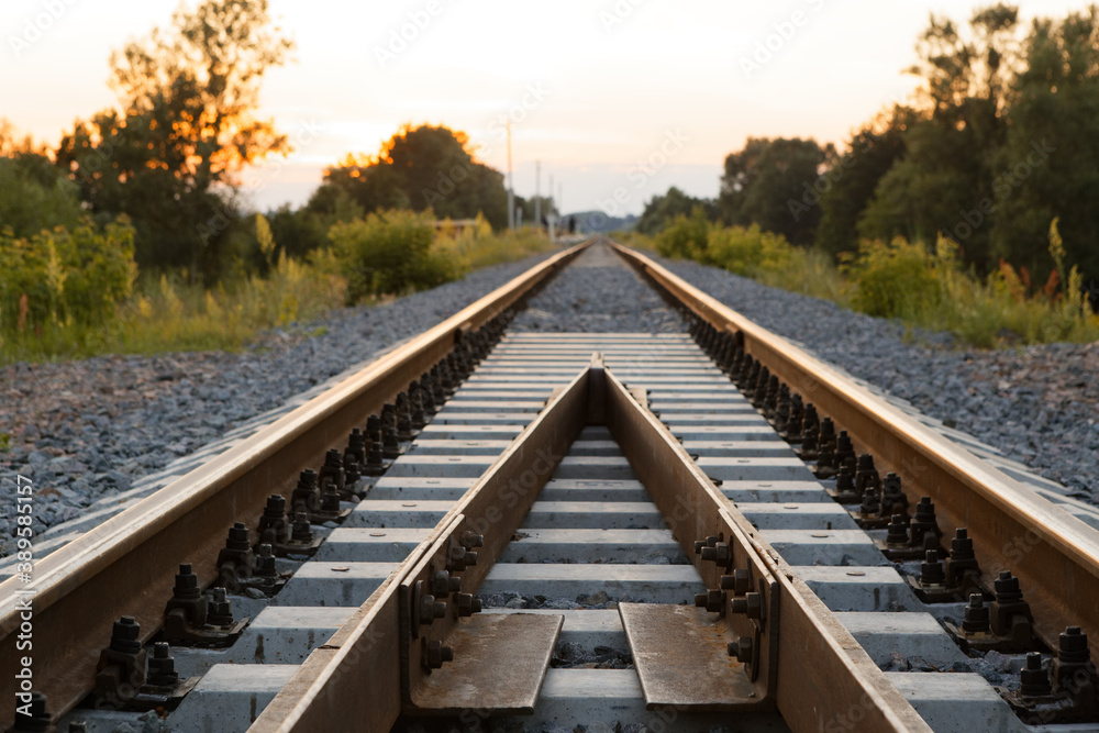 Fototapeta premium rails sleepers railway track at sunset of a summer day