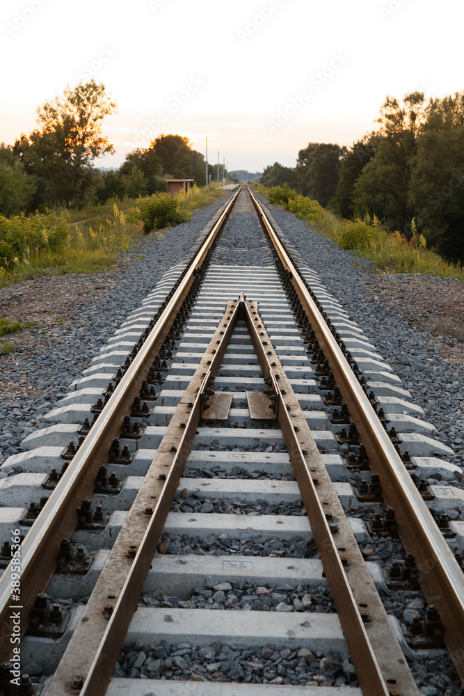 Fototapeta premium rails sleepers railway track at sunset of a summer day