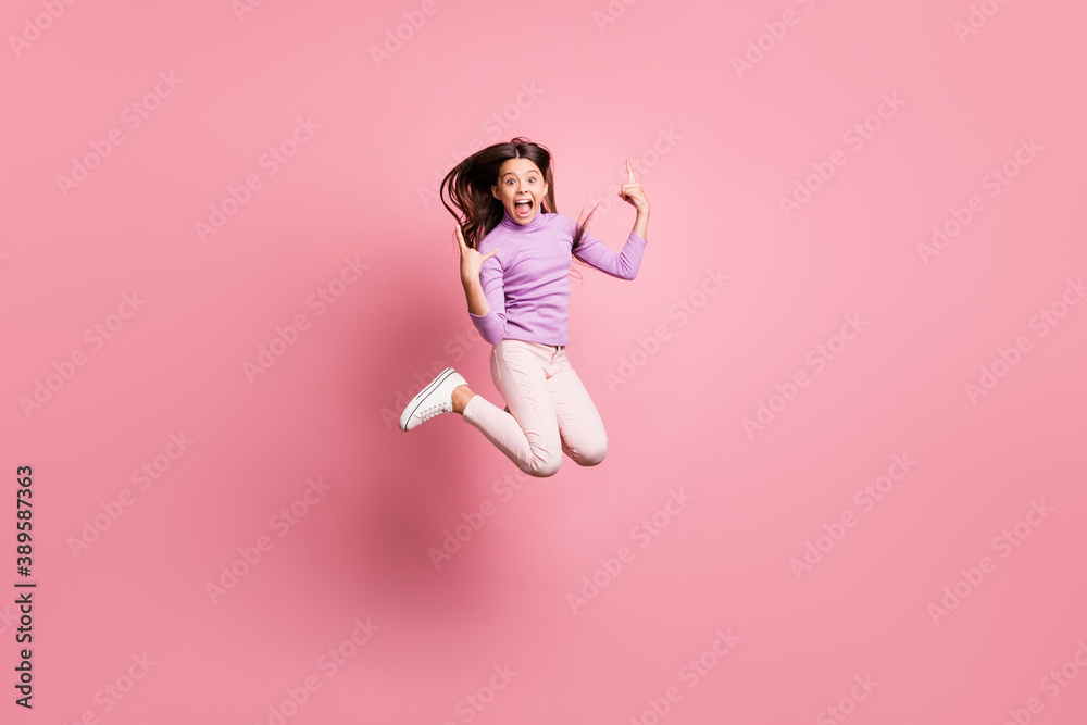Full size photo of crazy small kid girl jump show horns symbol wear purple sweater isolated on pastel color background