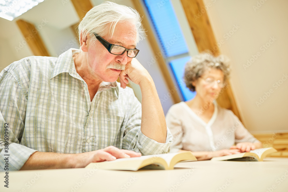 Senior is reading concentrated in a book Senior is reading concentrated in a book