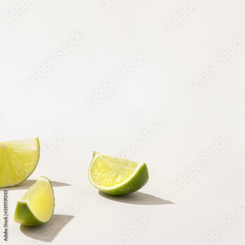 Slices of fresh green lime on white background