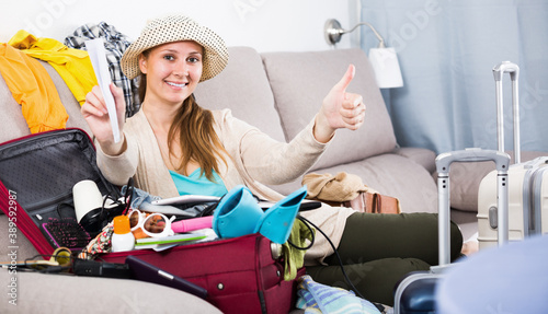 Happy young woman preparing to depart for holiday at home