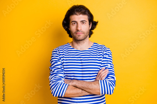 Photo of serious young middle eastern man sailor cross hands look in camera isolated over vivid yellow color background