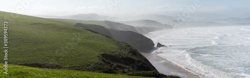 Fotografia green grassy cliffs drop down to the ocean coast in northern Spain