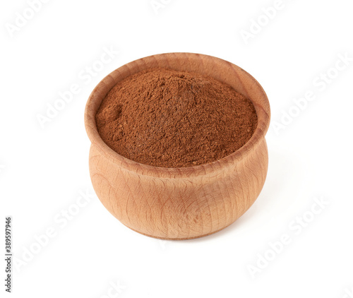 ground cinnamon in a wooden bowl isolated on white background